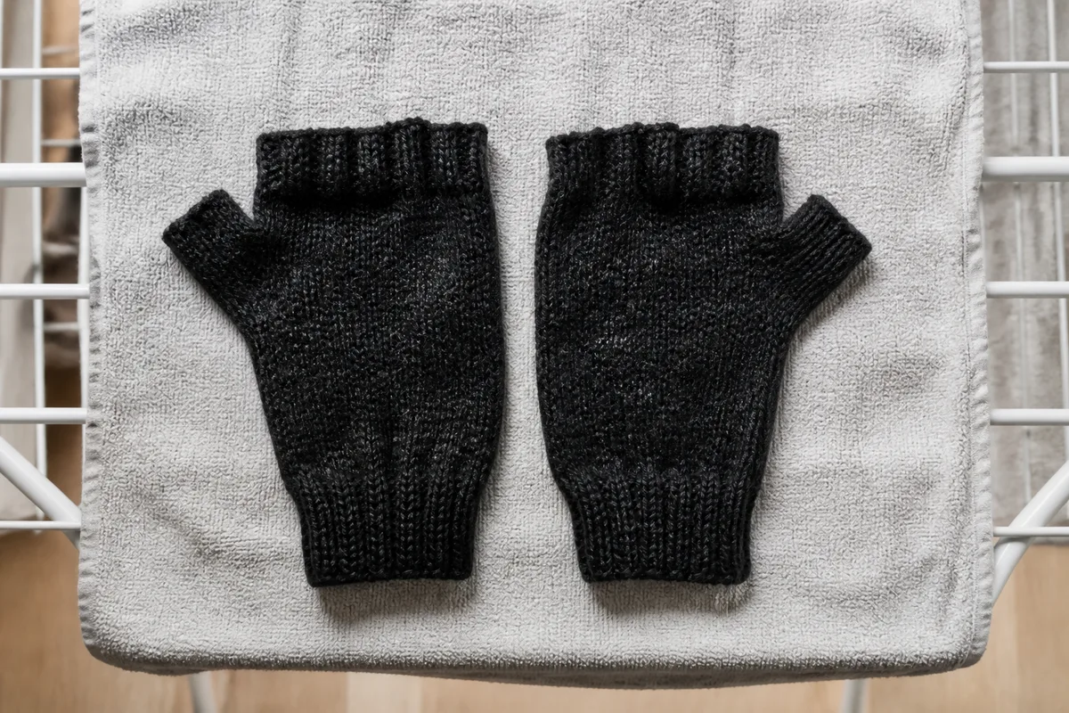 Mitaines noires en maille séchant à plat après un lavage à froid